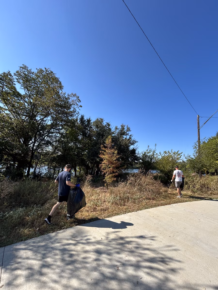 Volunteers walking the path with trash bags during the East Austin community clean up