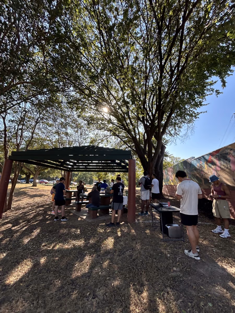 Volunteers gathering under the trees at the East Austin community clean up